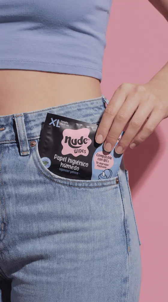 Un sachet de NUDE asomando del bolsillo delantero de unos jeans.